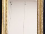 an antique gold framed mirror with a black background