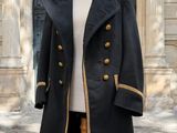 un manteau posé sur un mannequin devant un immeuble