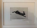 tableau représentant un chien noir bondissant dans les airs, dans un cadre blanc