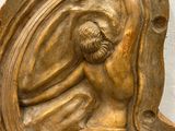 a statue of a man sitting on top of a shelf