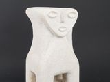 a white ceramic sculpture of a woman ' s face on a black background