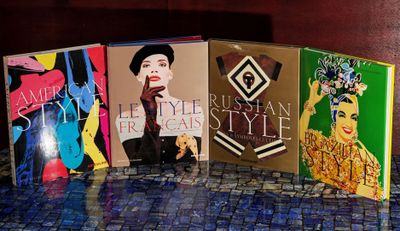 Trois livres sont posés sur une table recouverte d'une nappe bleue.