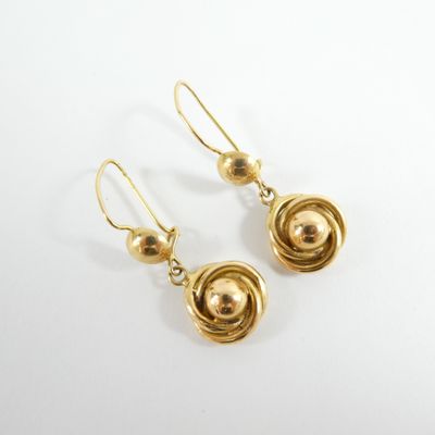 une paire de boucles d'oreilles dorées sur fond blanc