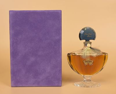 an image of a bottle of perfume next to a purple box