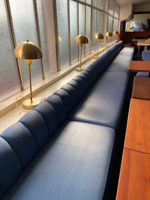 a row of blue couches in a room with a window