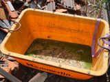 a yellow box with a purple handle sitting on a pile of junk