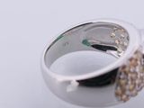 a close up of a ring with a green stone in it