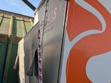 an orange and white fire truck parked in front of a building