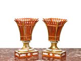deux vases dorés posés sur une table, sur fond blanc