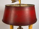 une image représentant une lampe rouge sur laquelle est posé un oiseau