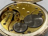 a close up of a pocket watch with gears on it