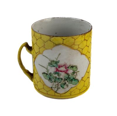 une tasse jaune et blanche ornée d'une fleur