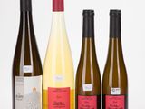 three bottles of wine are lined up on a white surface