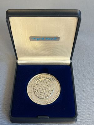 une image représentant une pièce d'argent dans une boîte bleue