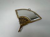 a gold fan shaped mirror hanging on a wall