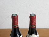 two bottles of wine sitting on a wooden table