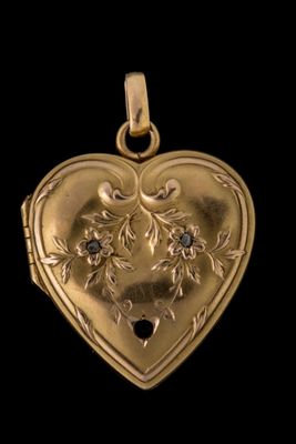 un pendentif ancien en forme de cœur doré, orné d'un diamant noir en son centre