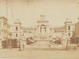 une vieille photo d'un grand bâtiment avec une tour horloge