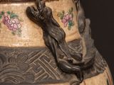 a large vase with a painting on it sitting on a table