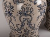 two blue and white vases sitting side by side