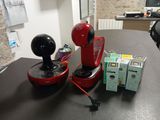 une cafetière rouge posée sur une table, à côté d'une boîte de thé