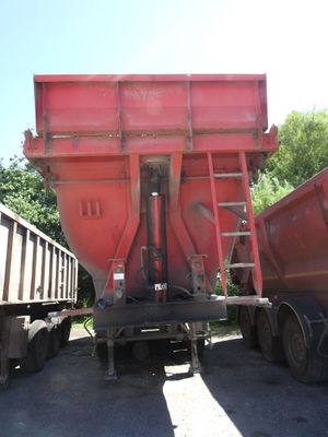 un camion-benne rouge garé à côté d'un autre camion-benne rouge