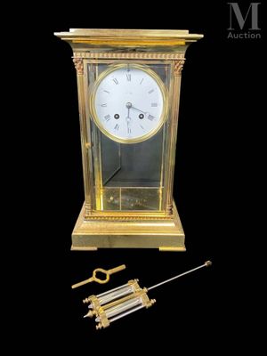 une horloge dorée avec un pendule sur fond noir
