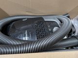 une boîte contenant un aspirateur et un tuyau