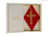 une croix rouge et or dans un coffret orné d'un ruban rouge