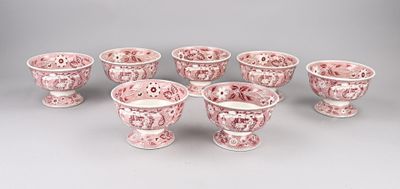 six tasses et soucoupes en porcelaine rose et blanche posées sur une table