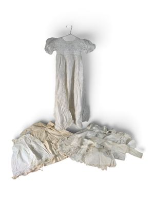 une robe blanche suspendue à un cintre sur un mur blanc