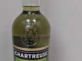 une bouteille de Chartreuse sur une table blanche