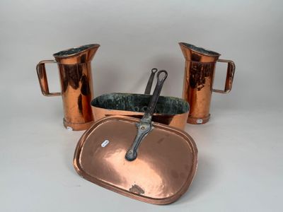 two copper pitchers and a copper pan on the table