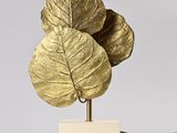 brass leaf table lamp with a white base and a gold leaf shade