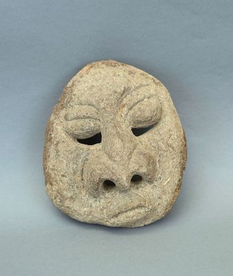 une image représentant un masque en pierre sur lequel figure un visage