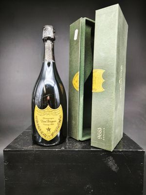 une vieille bouteille de champagne posée sur une boîte noire