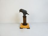 une statue représentant un oiseau perché au sommet d'un socle