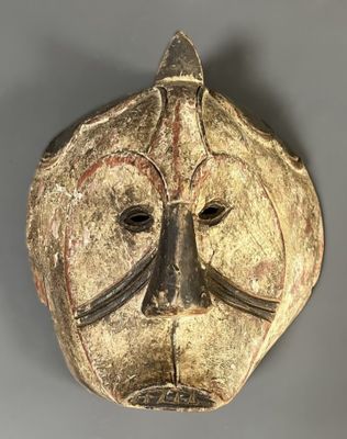 gros plan d'un masque en bois sur une surface grise