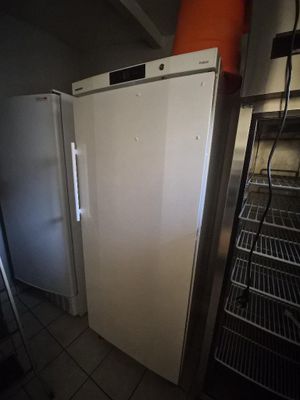 a white refrigerator in the corner of a kitchen next to a shelf
