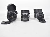 three camera lenses sitting next to each other on a white surface