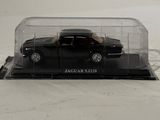 a black car in a clear box on a white surface