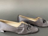 pair of women ' s gray shoes with bows on the toes