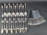 many forks and spoons laid out on the table