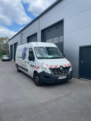 a white van parked in front of a building next to a garage