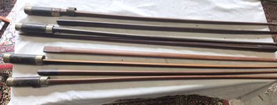 six cannes en bois sont alignées sur un drap blanc