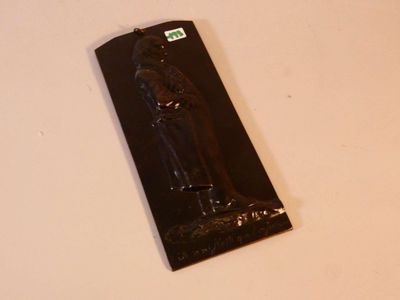 un objet noir sur une surface blanche avec un fond noir