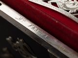 a close up of a red velvet case with a silver design on it