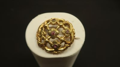 Gros plan sur une bague en or ornée de pierres roses