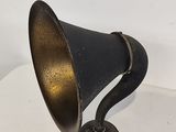 an old fashioned black and gold lamp on a white table