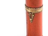 a small red box with a gold decoration on it